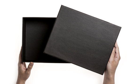 Two hands hold a empty(blank) black gift box and open isolated white