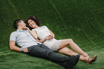 couple in love lying on green artificial grass