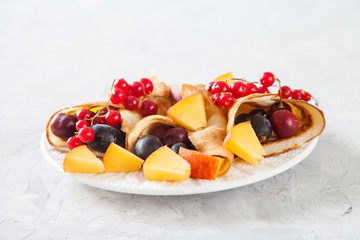 pancakes with berries in a plate on a table, selective focus