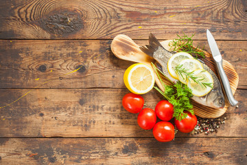 fish with a lemon and tomatoes on a table, selective focus,  top view