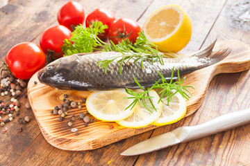 fish with a lemon and tomatoes on a table, selective focus