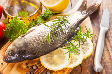 fish with a lemon and tomatoes on a table, selective focus