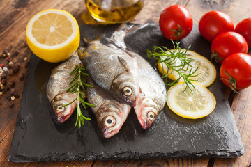 fish with a lemon and tomatoes on a table, selective focus