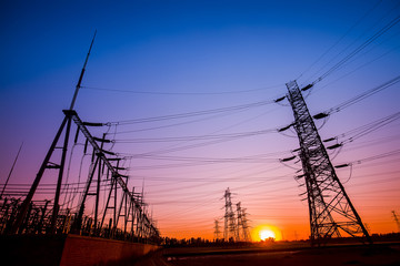 Fototapeta premium The silhouette of the evening electricity transmission pylon