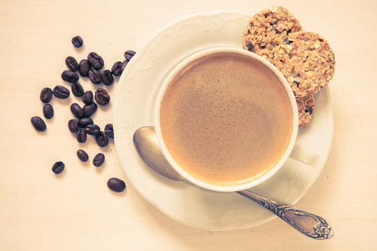 coffee in a cup and oat cookies on a table, selective focus, image is tinted, top view