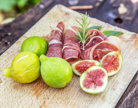 Ripe fig fruits and bacon or prosciutto. Food to accompany the d