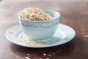 oat flakes in a bowl on a table, selective focus