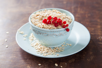oat flakes in a bowl on a table, selective focus
