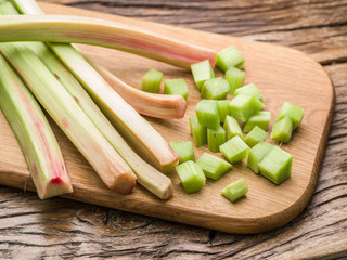 Edible rhubarb stalks on the wooden table.
