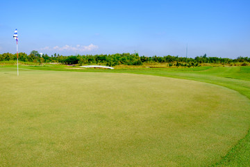 Fototapeta premium zielone pole golfowe i błękitne niebo chmury do użytku w tle