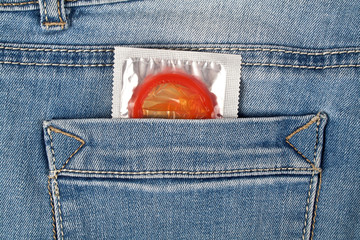 Red condom in blue jeans pocket