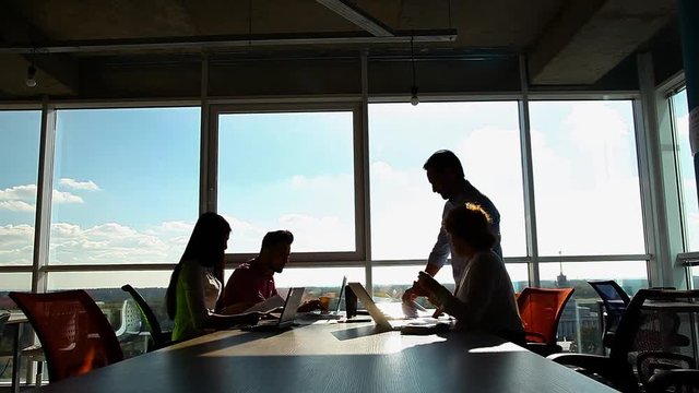 Business people working in board room, looking through documents and discussing business questions or issues while sitting in board room in office.