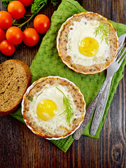 Tartlet meat with egg in pan on board top