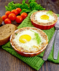 Tartlet meat with egg in pan on dark board