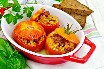 Tomatoes stuffed with bulgur in pan on board