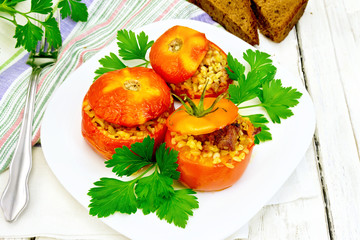 Tomatoes stuffed with bulgur and parsley in plate on table