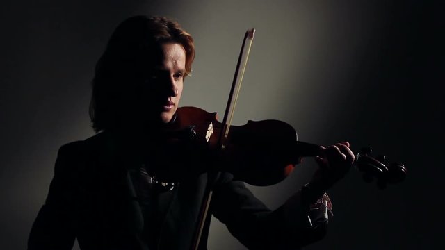 Woman Playing On Violin In Dark
