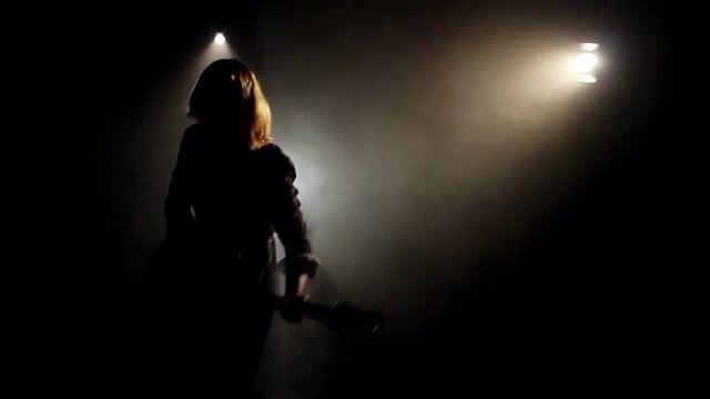 Silhouette Of Woman Playing On Electric Guitar In Smoke