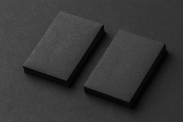 Mockup of two vertical business cards stacks at black textured