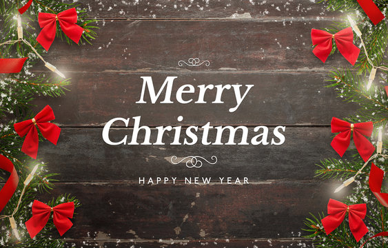 Merry Christmas and Happy New Year card. Wooden table with Christmas tree and decorations.