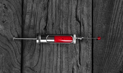 syringe with blood, the blood of the vampire, black wooden background