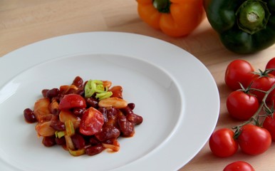 Mexican chilly beans in tomato sauce with peppers, leek and onion. Spicy food.