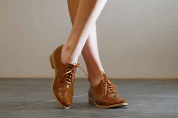 Closeup photo of patent-leather female shoes with laces. Walking