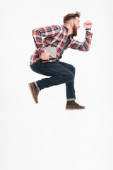 Naklejka premium Side view of a casual guy in plaid shirt jumping