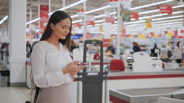 Happy Woman with Tablet Shopping at The Supermarket - Young girl in a market store with a PC tablet in a department store