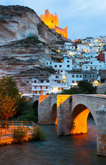 dusk view of Alcala del Jucar with   castle and bridge