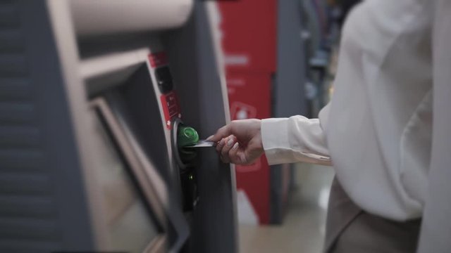 young woman inserting a credit card to ATM, beautiful girl banking