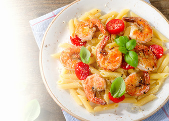 Penne pasta with shrimps, tomatoes and herbs.