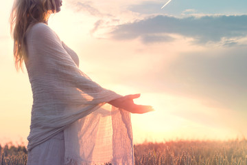 dreamy woman holding the sun in her hands