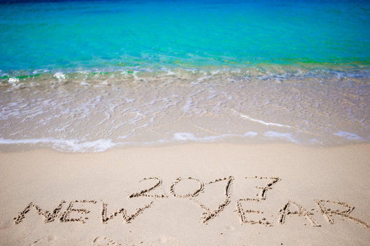2017 New Year written in the white sand