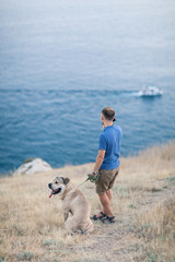 Young caucasian male walking with dog during sunrise