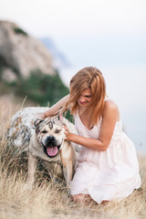 Young caucasian woman walking with dog during sunrise