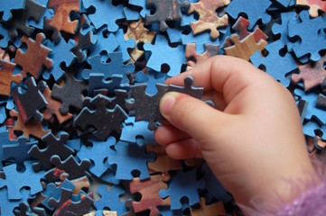 Kinderhand mit Puzzleteilen