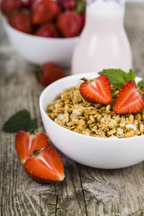 Granola with strawberry on a wooden table. Healthy eating.