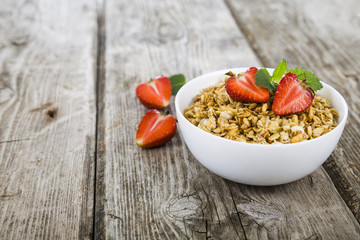Granola with strawberry on a wooden table. Healthy eating for br