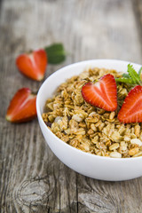 Granola with strawberry on a wooden table. Healthy eating for br