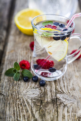 Homemade lemonade with fresh berries on a wooden table.Cocktail
