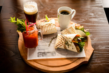 Grilled sausage meat in pita bread, beer, coffee