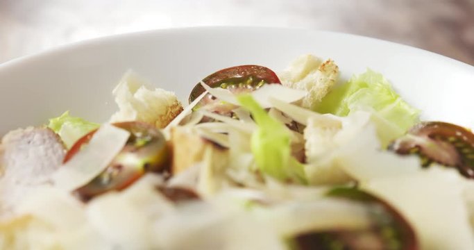caesar salad closeup camera backwards over caesar salad with kumato, 4k 60fps prores footage