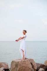 Young girl on the rocks in the sea