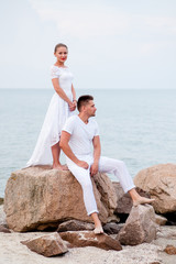 Young couple on the rocks in the sea