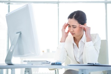 Obraz na płótnie Canvas Stressed businesswoman working at her desk