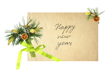 New year card with a bouquet of pine branches and a handwritten inscription "happy new year" on aged paper. handmade.  