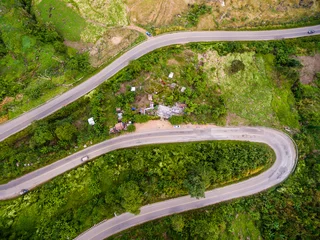 Fototapeten Aerial view of crooked path of road on the mountain, Shot from d © Naypong Studio