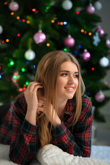 Girl smiles near Christmas tree