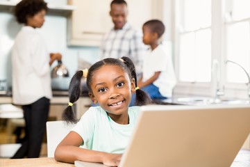Daughter using laptop in the kitchen